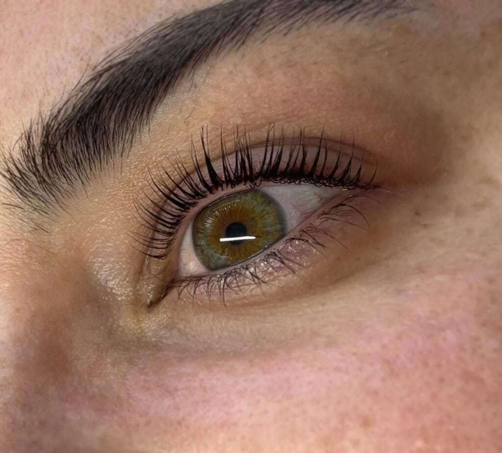Beautiful green eye with professional lash extensions and perfectly shaped eyebrow at YOLOve beauty salon