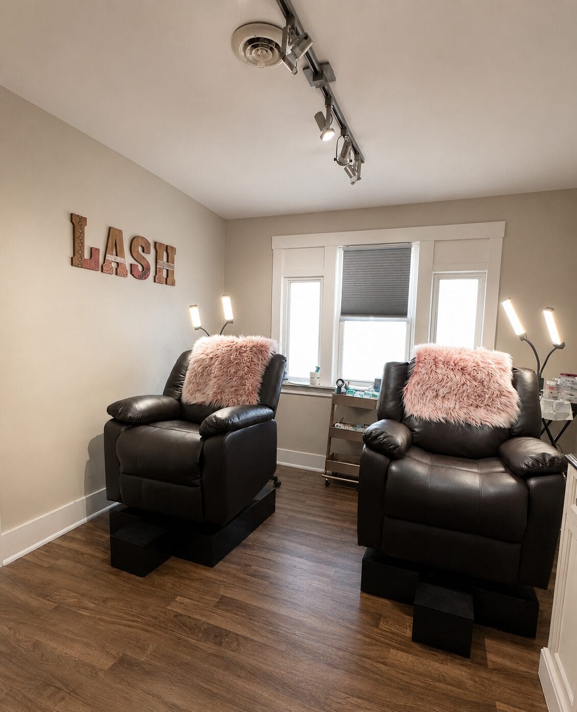 Luxurious lash extension treatment room at YOLOve beauty salon with black leather chairs and pink pillows