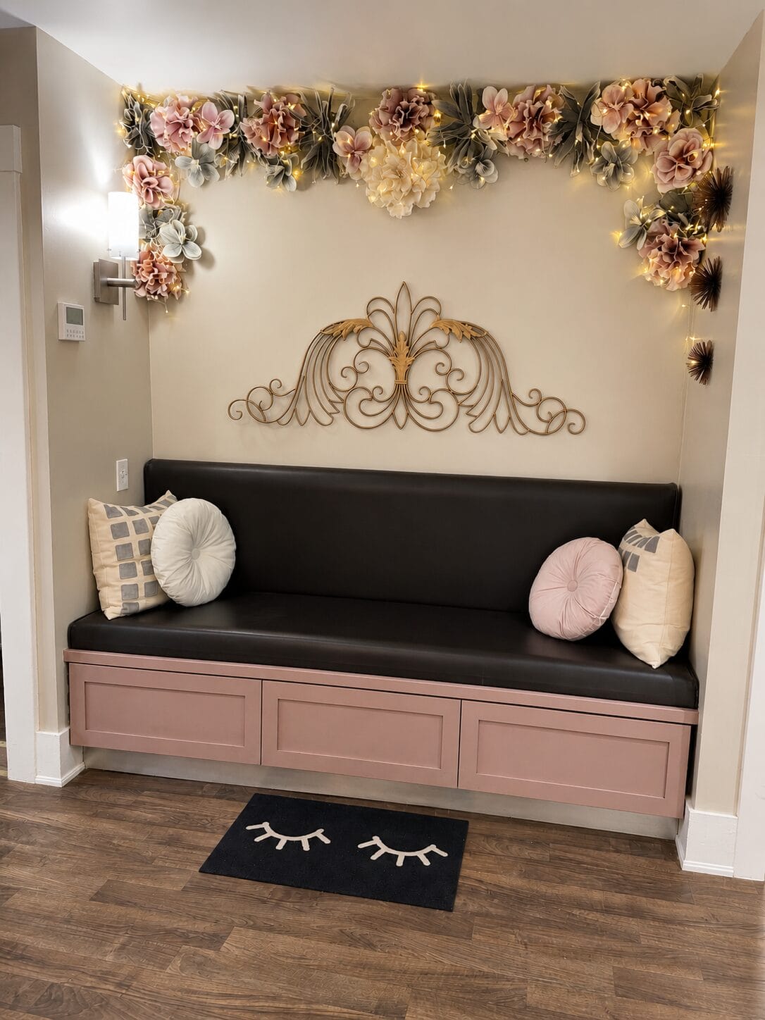 Elegant YOLOve beauty salon waiting area with pink built-in bench, floral wall decor, and eyelash rug in Dartmouth