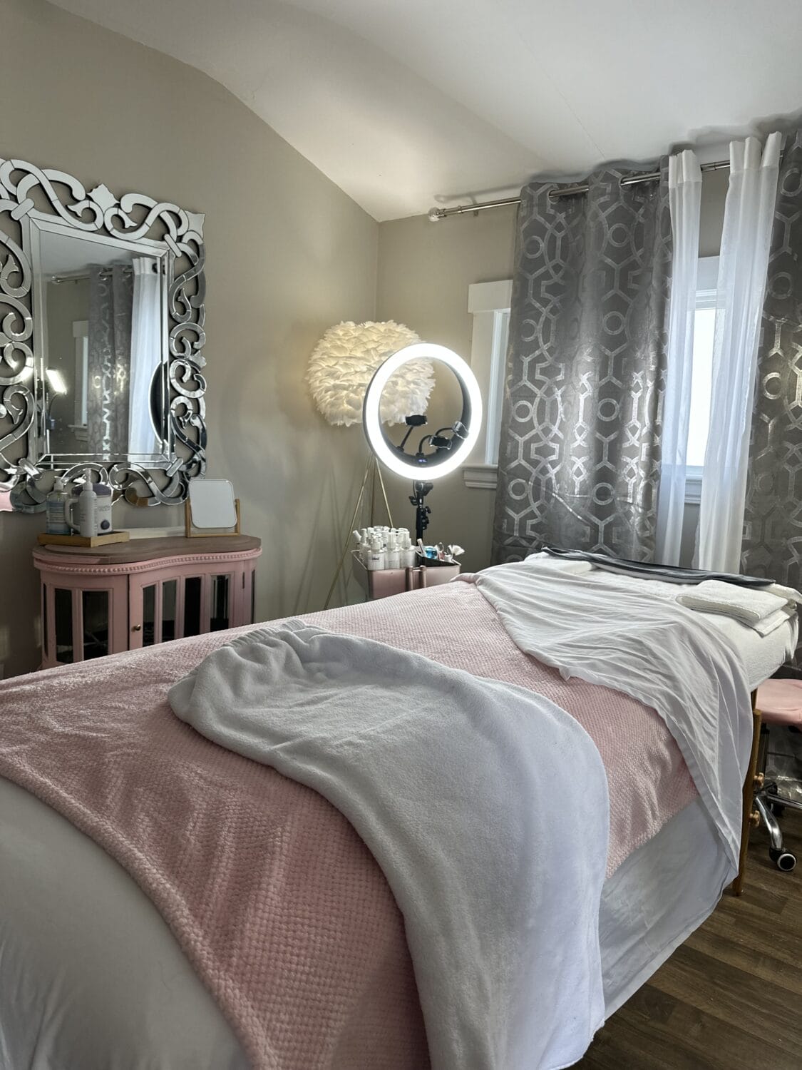 Luxurious spa treatment room at YOLOve beauty salon featuring massage table, ring light, and elegant decor