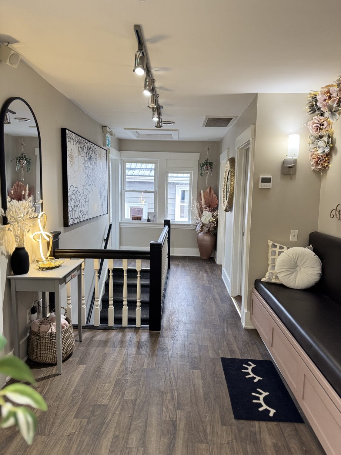 Welcoming upstairs hallway at YOLOve beauty salon spa in Dartmouth with modern decor, built-in seating and pampas grass